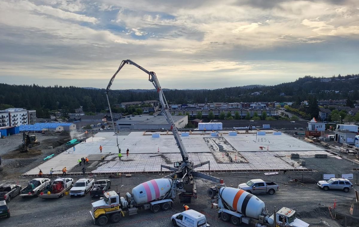 Large commercial concrete placement with boom pump and ready-mix trucks