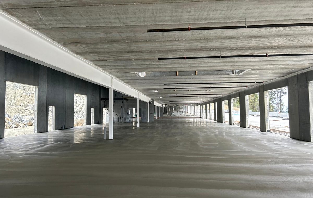Long interior concrete floor slab in a completed industrial structure