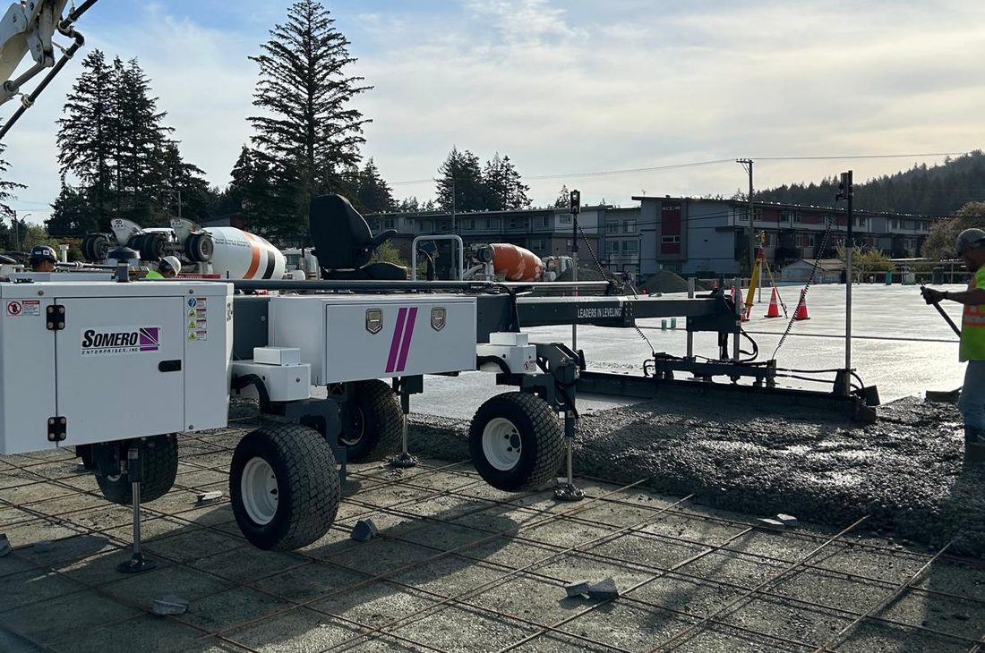 Laser screed placing a large flat concrete floor slab on site